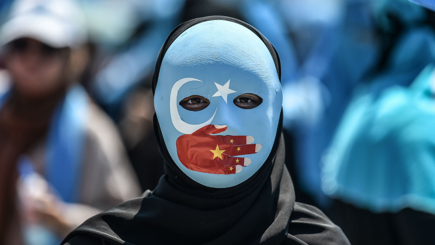 A demonstrator wears a mask showing solidarity with China&#039;s Uighur population.