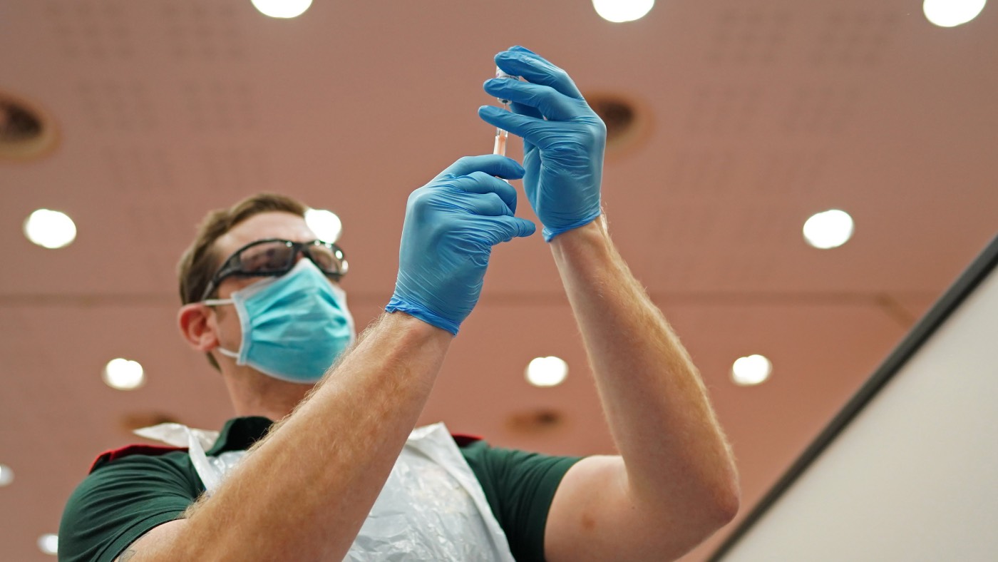 An NHS nurse prepares a Covid-19 vaccination