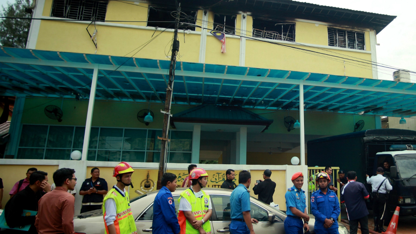 Rescue workers outside the burnt-out school in Kuala Lumpur