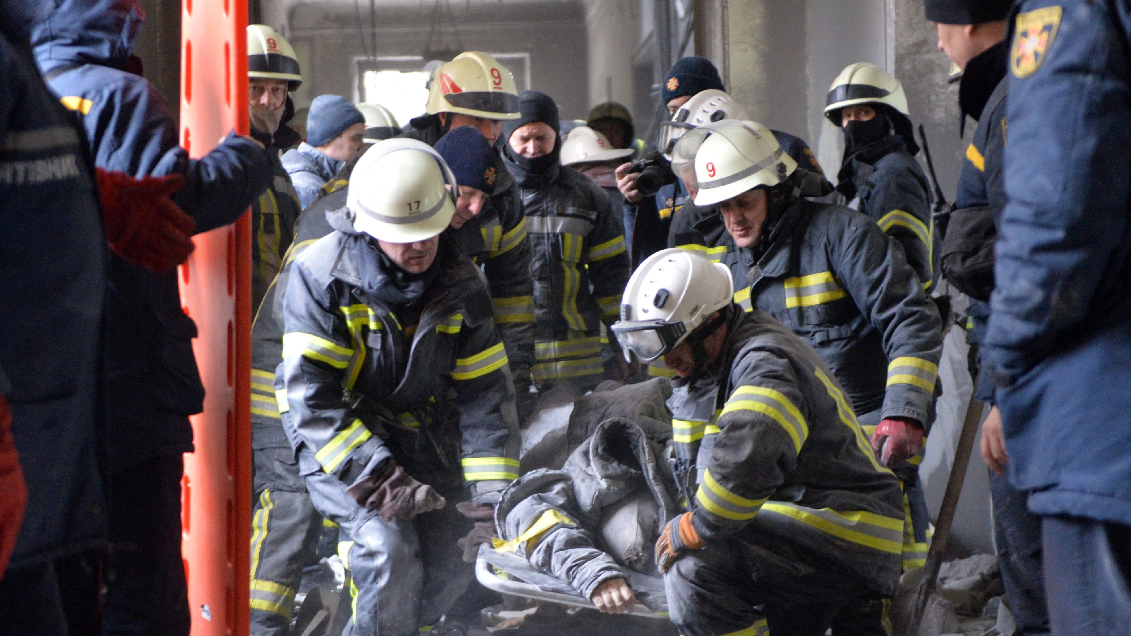 Ukrainian emergency services remove a person injured during shelling on Kharkiv City Hall  