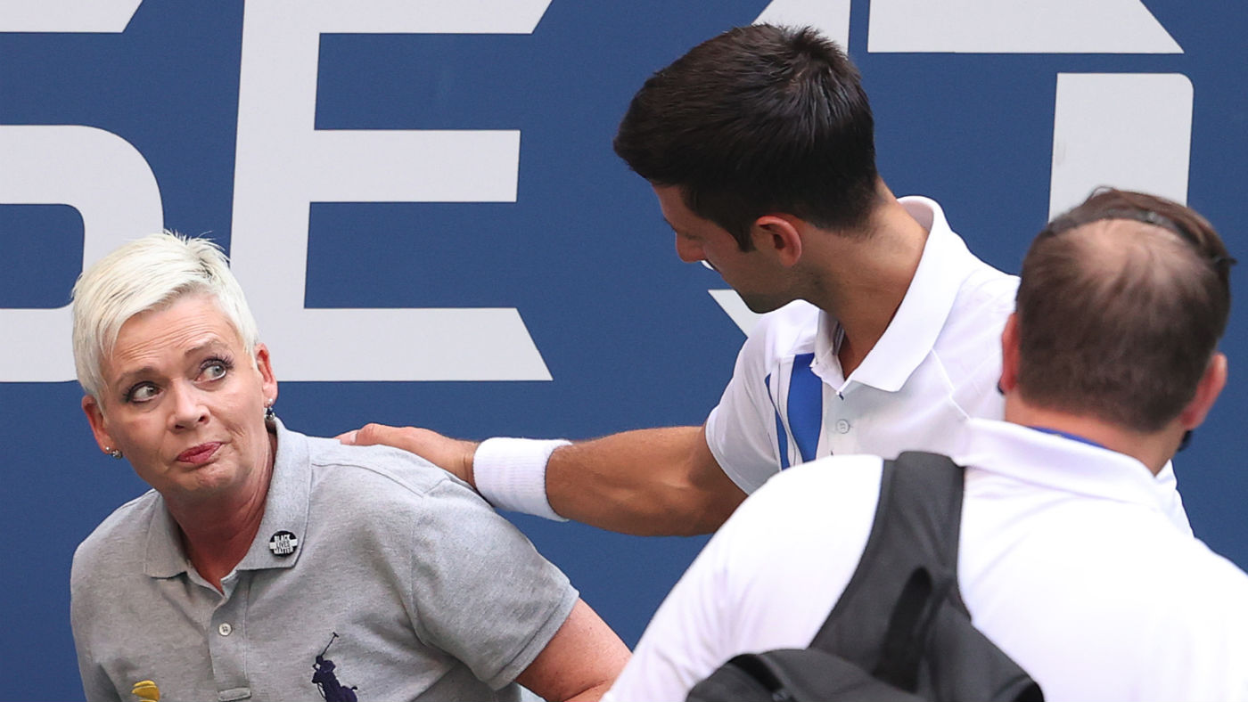 Novak Djokovic tends to a line judge who was hit with the ball during his US Open clash against Pablo Carreno Busta 