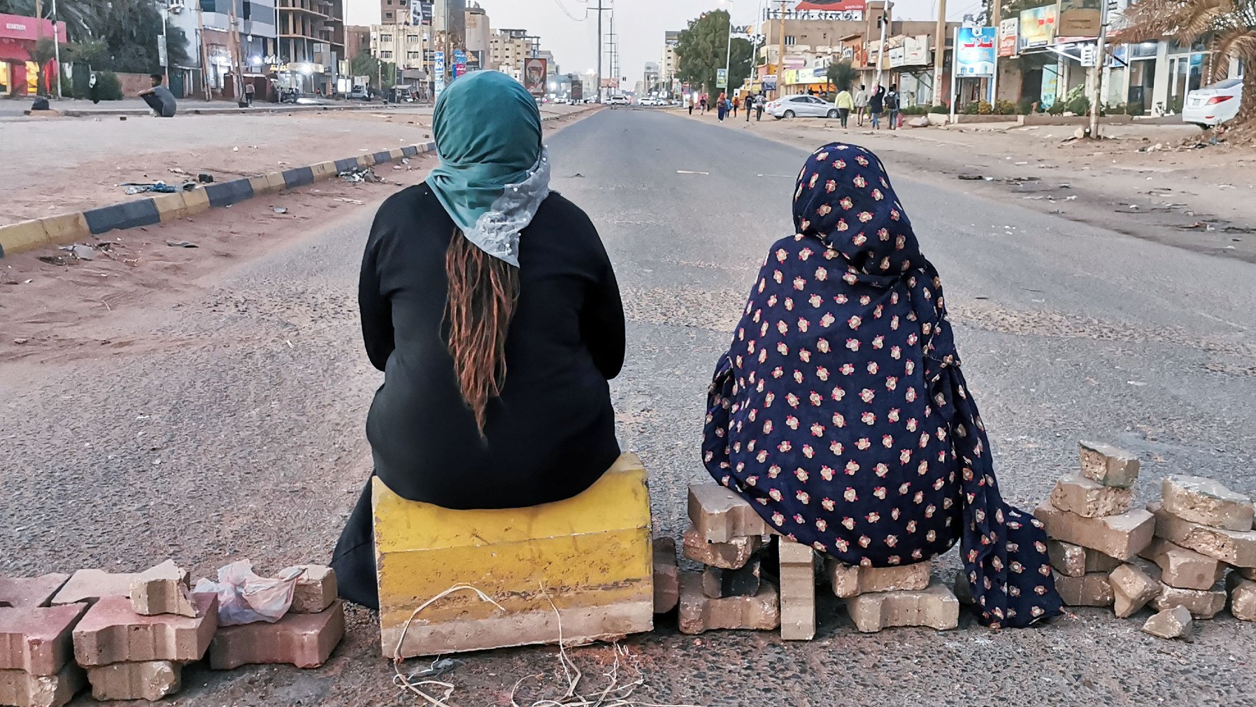 Sudanese women sit on a brick barricade in Khartoum during a demonstration earlier this year 