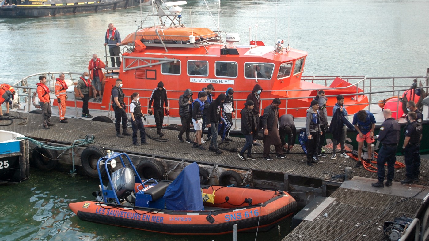 Migrants disembark from a vessel in Calais 