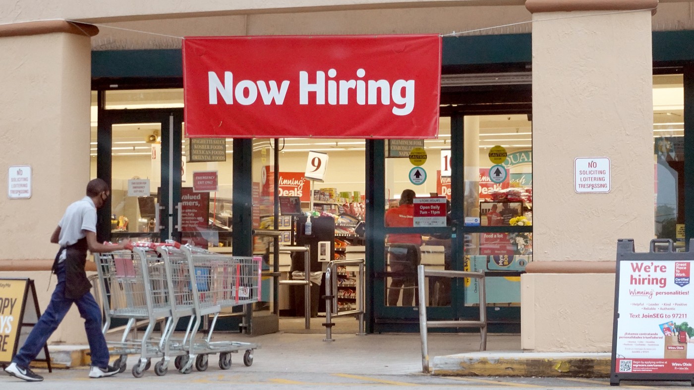 A now hiring sign outside a supermarket in Florida  