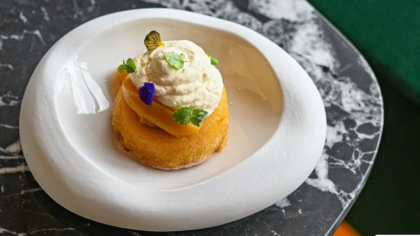 Rum baba, whipped cream and pressed peaches
