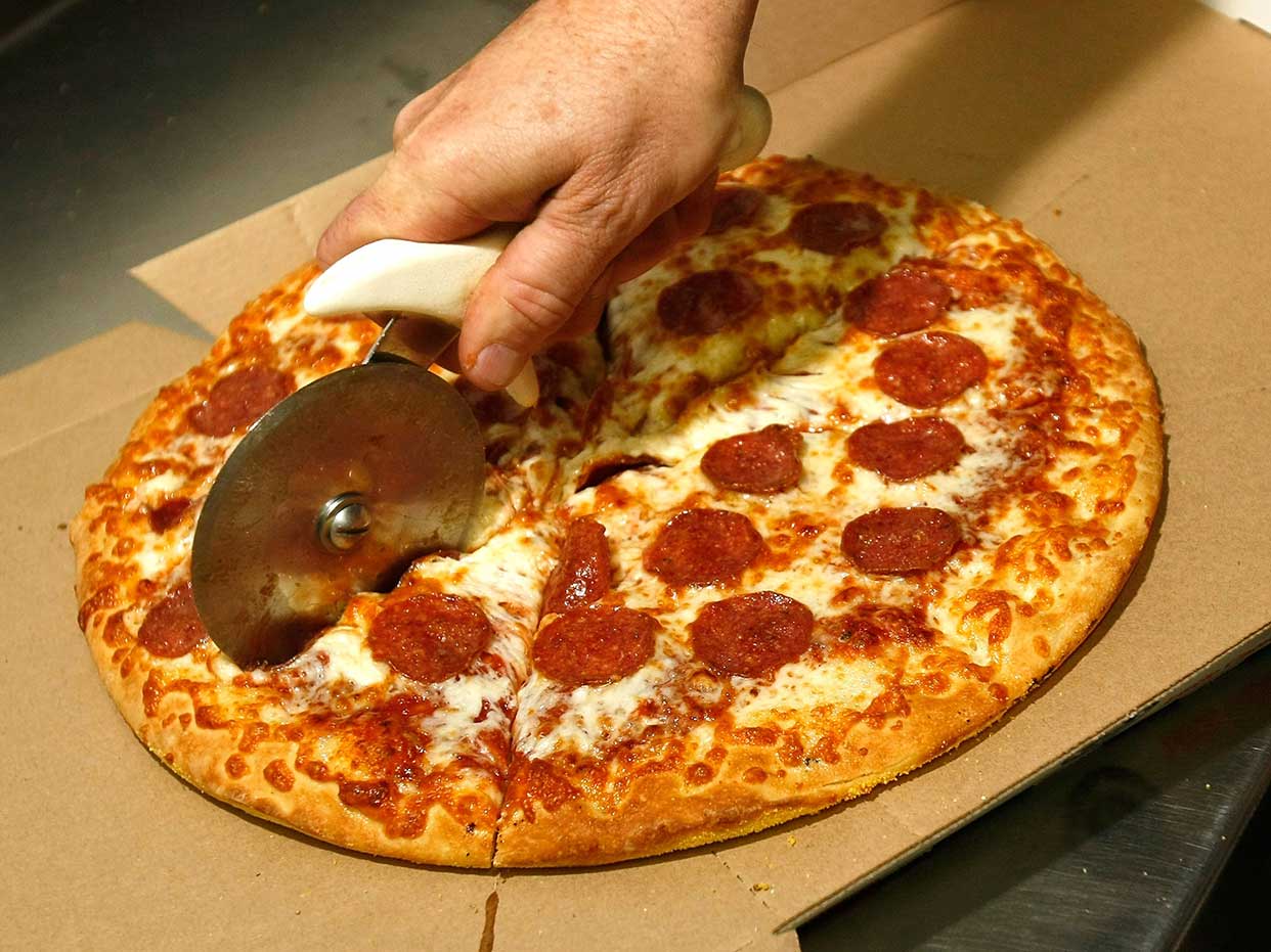 A pizza being cut 