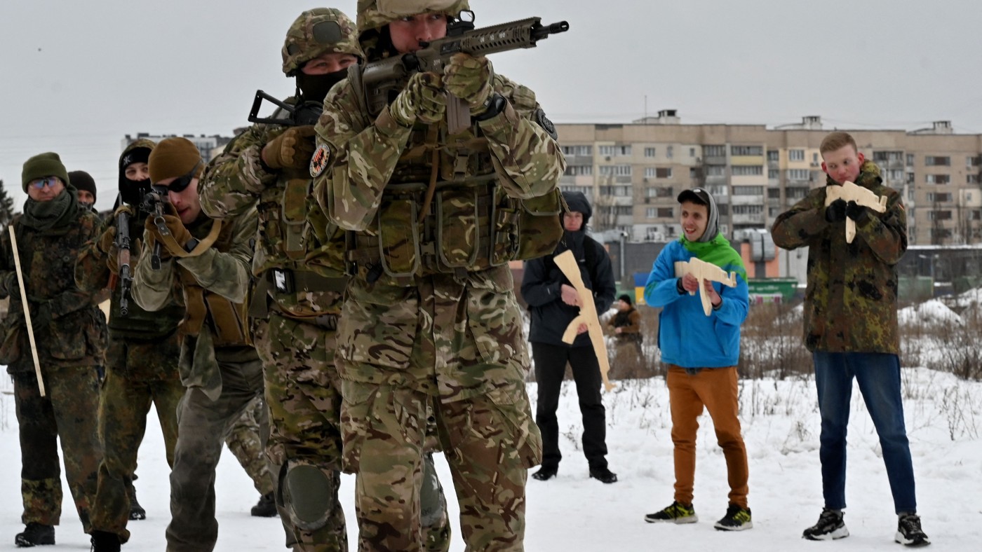 A military instructor teaches civilians holding wooden replicas of Kalashnikov rifles, as they take part in a training session in Kiev