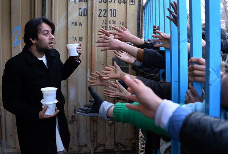 Afghan men and children reach out for food donated by a charity in Mazar-i-sharif on January 22, 2015.Afghanistan&#039;s economy has improved significantly since the fall of the Taliban regime in 