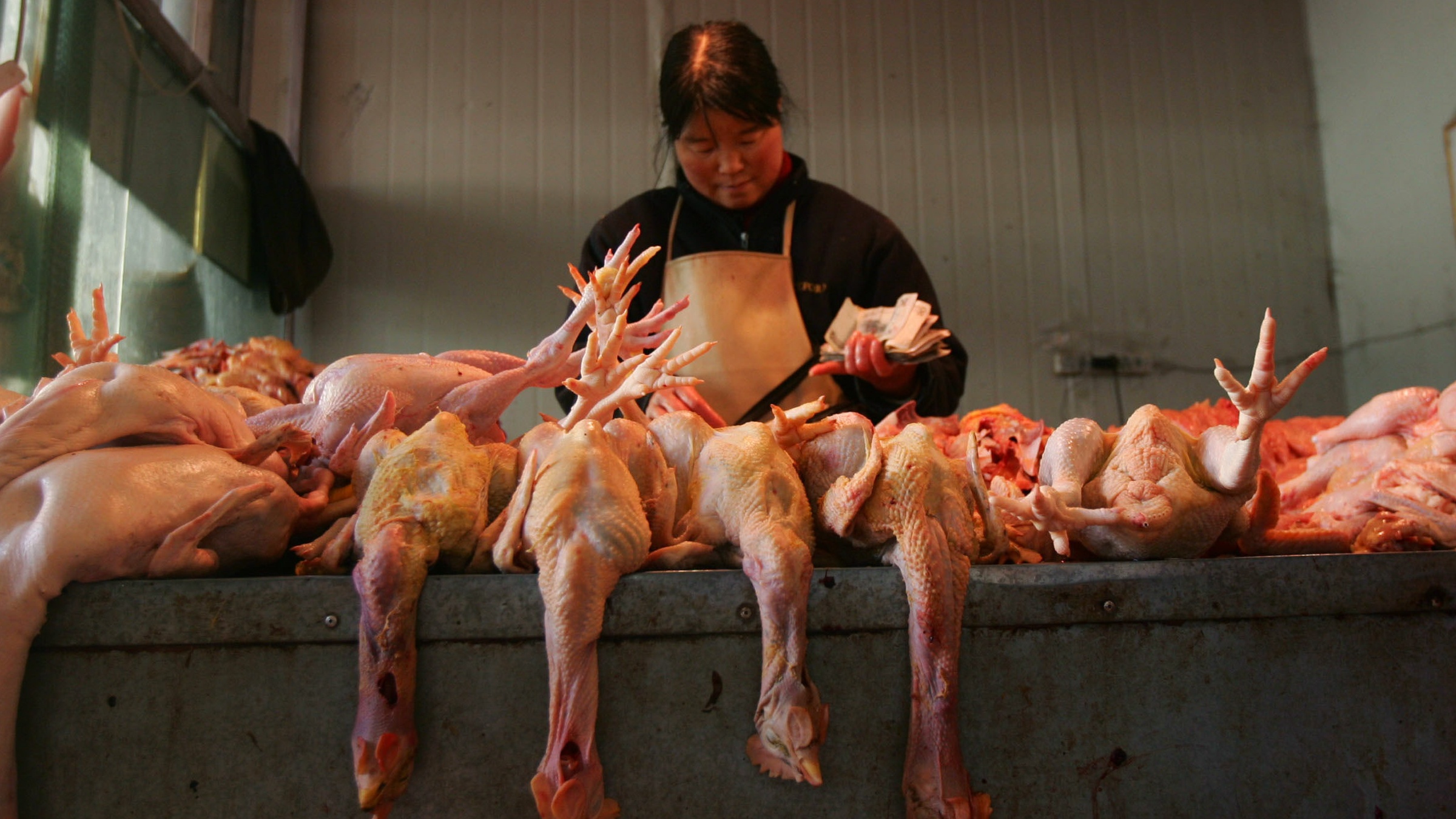 A vendor slaughters chickens at a poultry market in east China