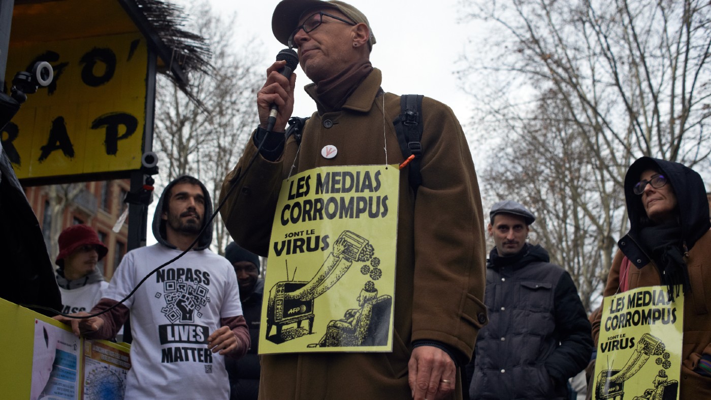 A protester in France with a placard reading ‘Media is the virus’