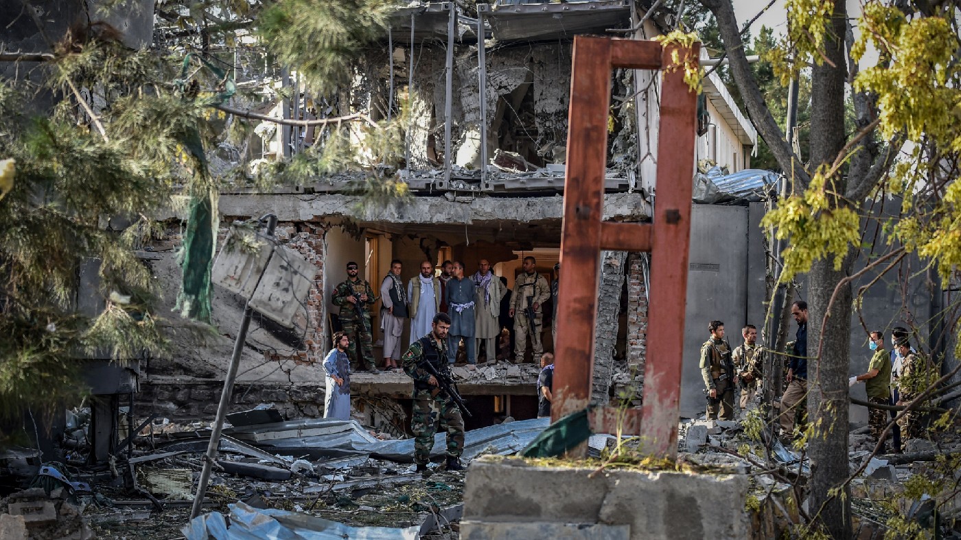 Afghan security personnel inspect the site near a car bomb explosion