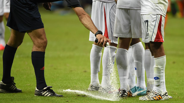 A referee uses the spray during a World Cup match