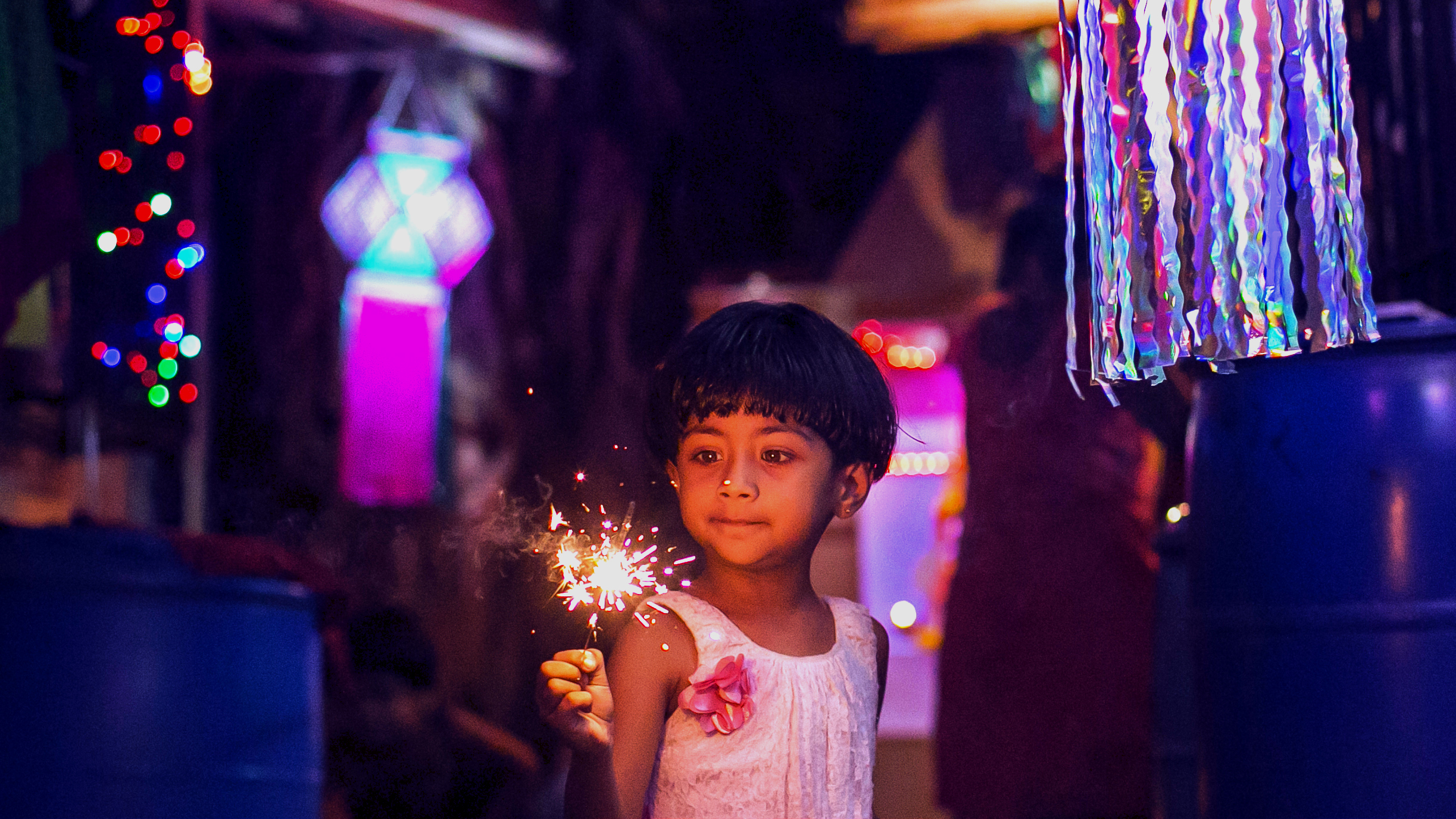 A girl holds a firecracker to celebrate the annual festival of Diwali in Mumbai