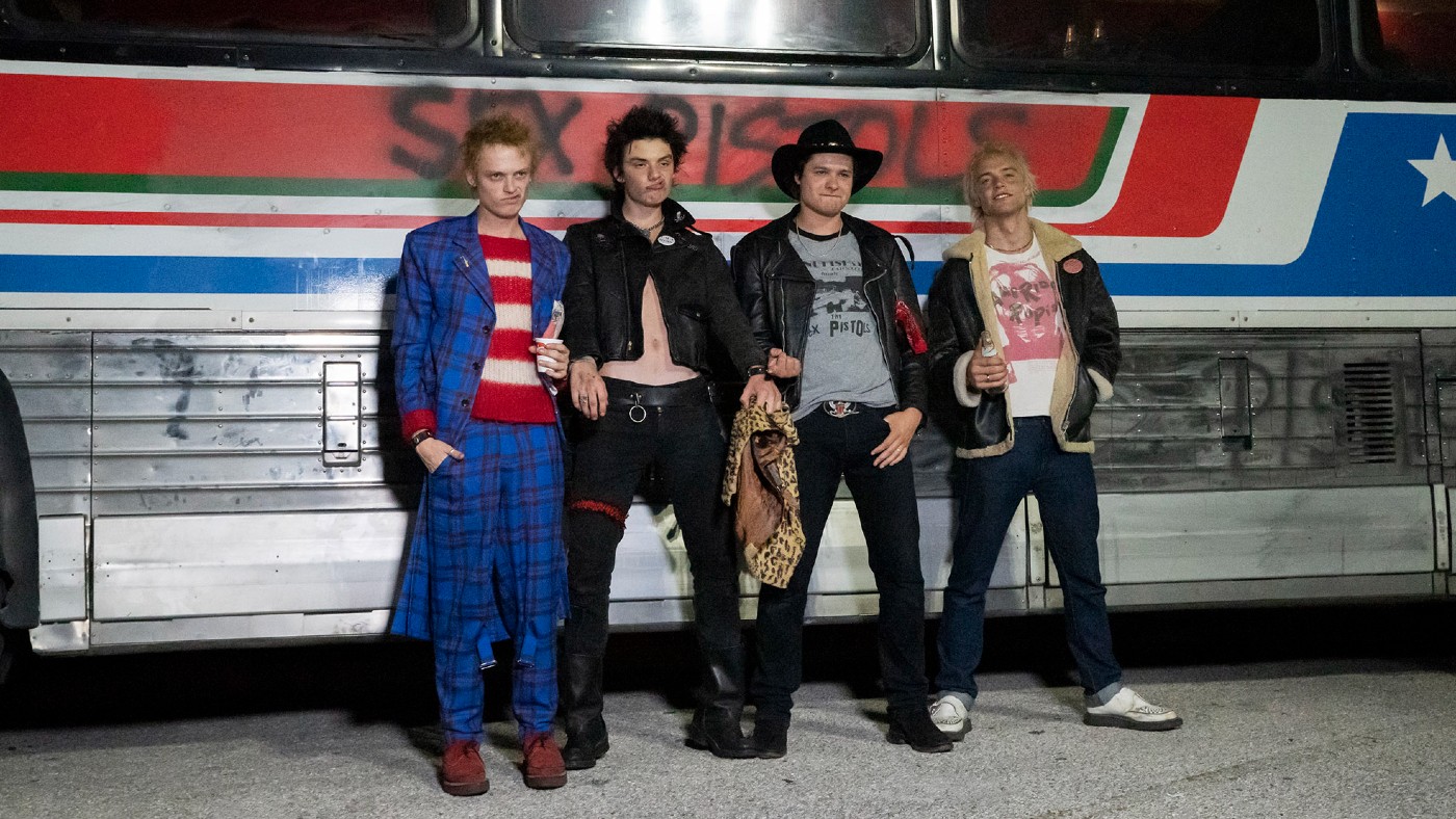 Still from the TV show of the band in front of a bus