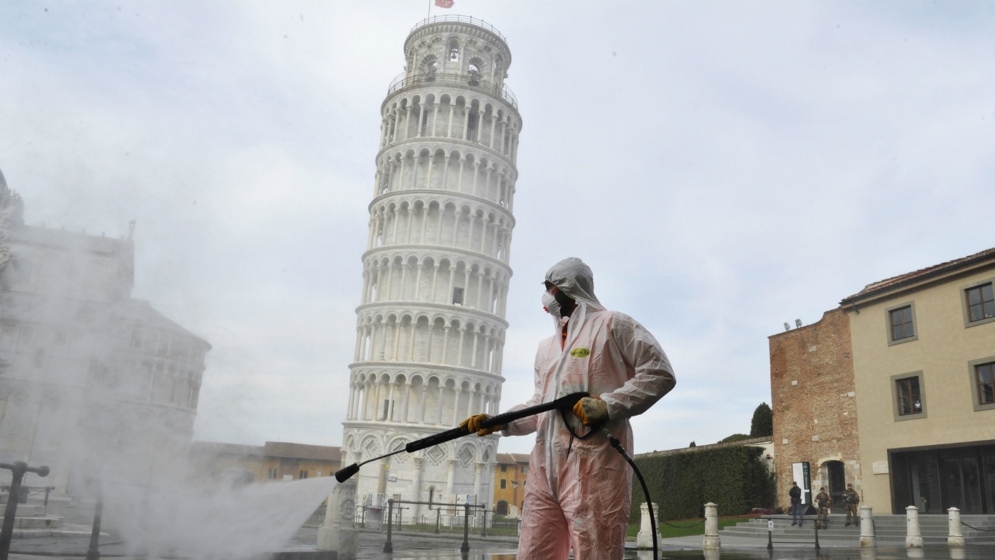 Health workers disinfect the area around the Tower of Pisa