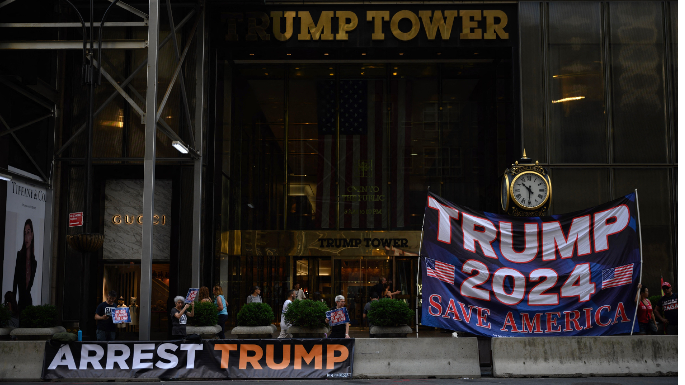 Banners reading ‘Arrest Trump’ and ‘Trump 2024’ 