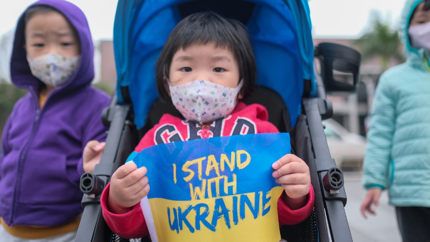 Child holding &#039;I stand with Ukraine&#039; poster